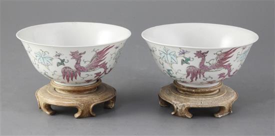 A pair of Chinese famille rose phoenix bowls, Guangxu period, 15.4cm diameter, wood stands